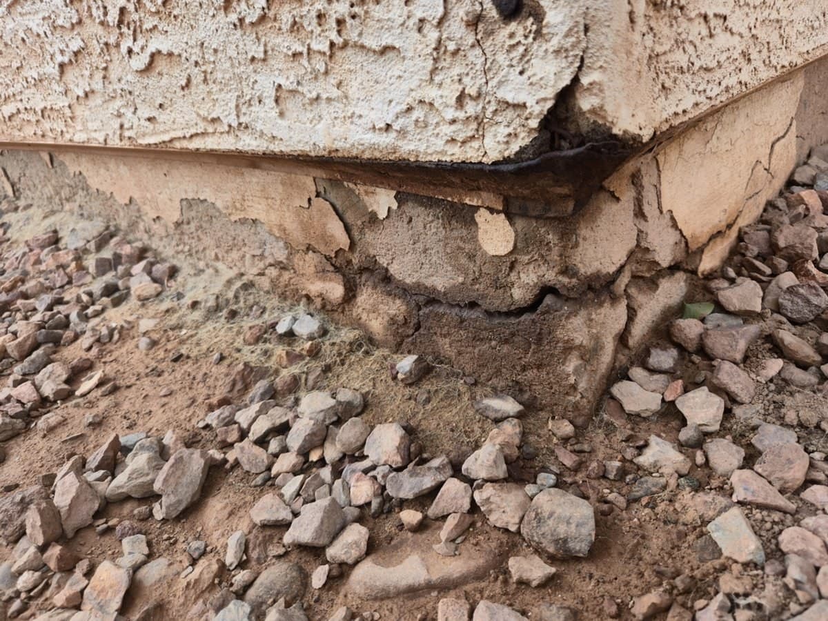 Corner of a post-tension foundation with concrete breaking away from rusted steel