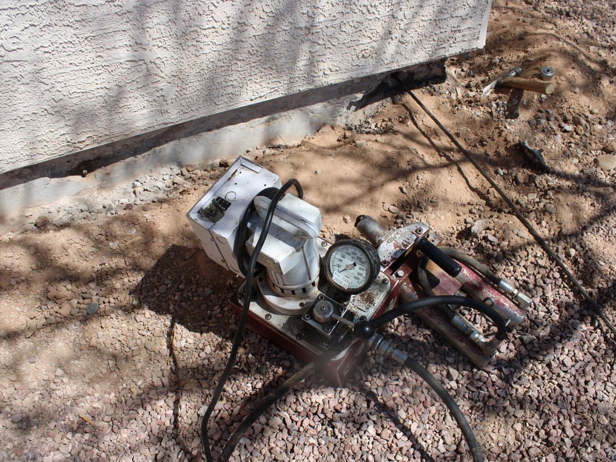 Hydraulic pump and pressure gauge used to stress post-tension tendons